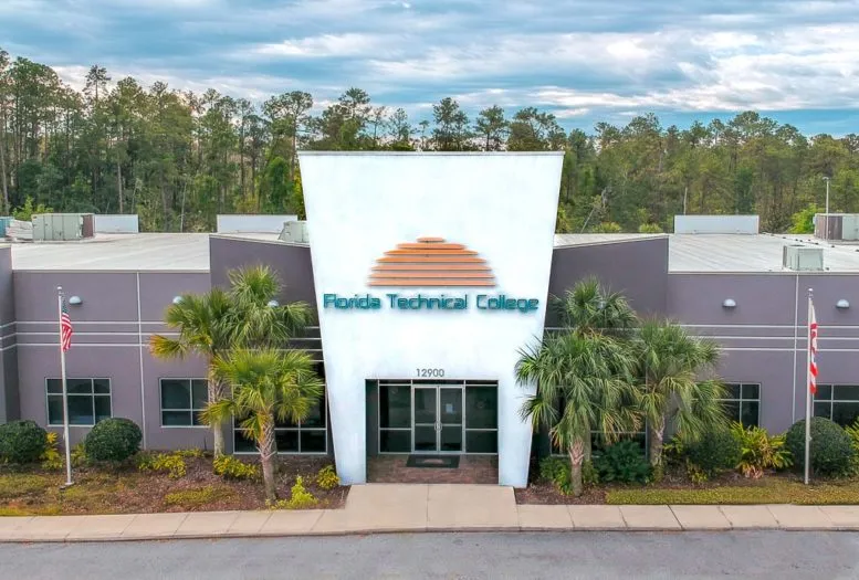 Front view of Florida Technical College with palm trees under a blue sky